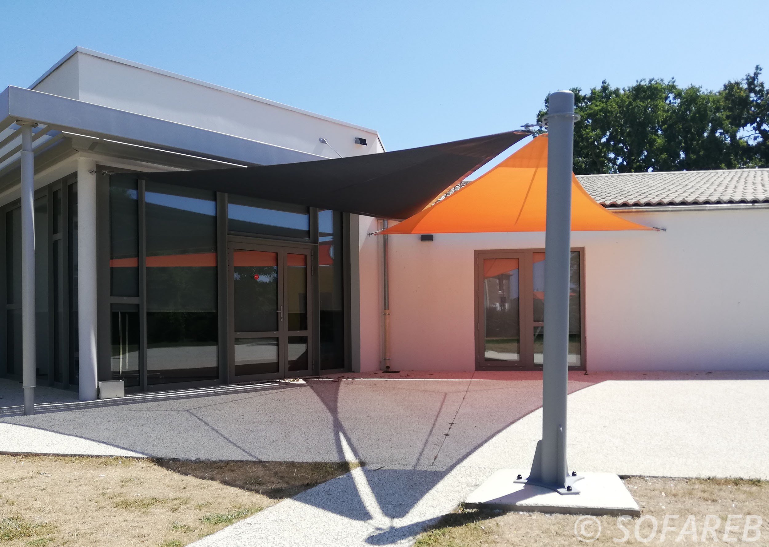 Voiles dombrage triangulaires orange et noire installée à lextérieur de la Mairie de Thorigny en Vendee