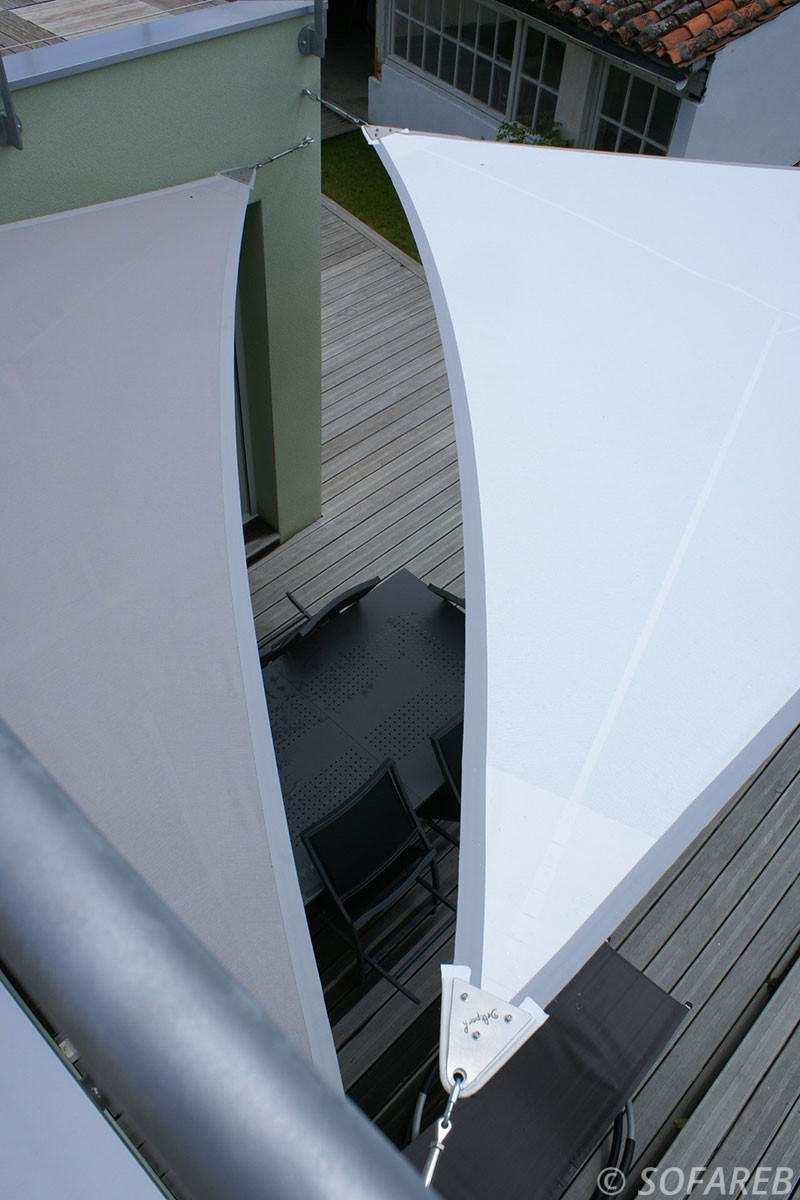 Vue de pres du système d'accroche d'une voile d'ombrage triangulaire blanche