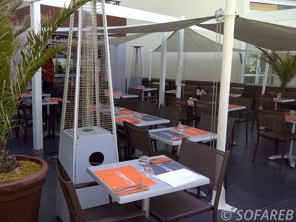 Voiles dombrage blanches et de forme triangulaires qui couvrent la terrasse dun restaurant