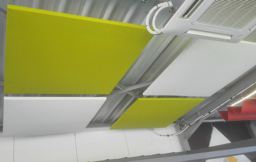 Panneaux acoustiques verts et blancs accrochés au plafond du Showroom Sofareb en Vendée