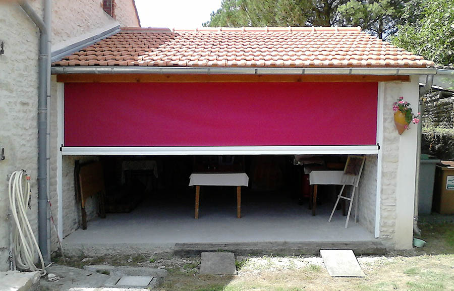 Store vertical rose installé pour abriter le garage d'une maison