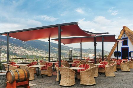 Protection solaire pergolas avec bâche rouge pour protéger la terrasse d'un restaurant